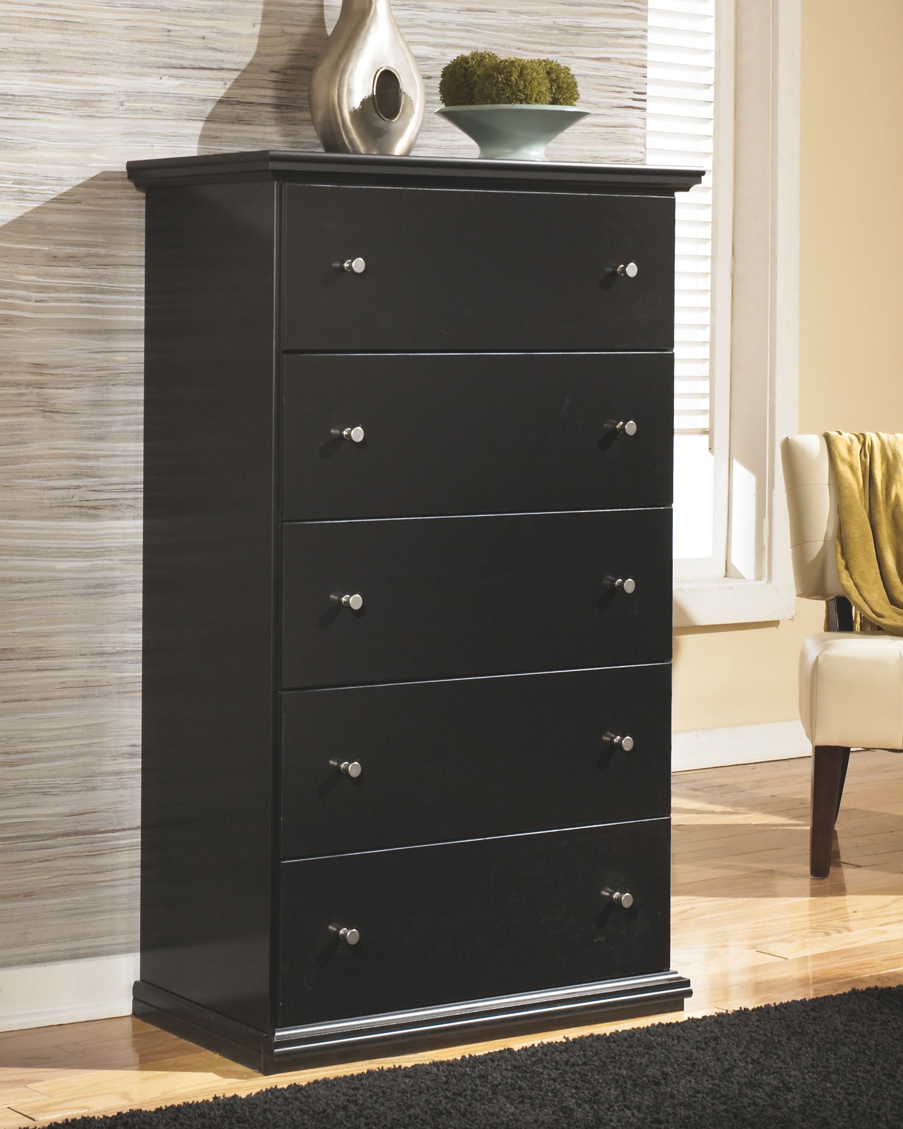 Black five-drawer chest with angled view, four visible drawers and metal knobs