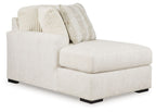 Ivory corner chaise with textured cushions and patterned throw pillows