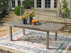 Rectangular outdoor dining table with beige top and four straight legs