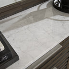 Dark brown dresser top with white marble surface and raised edge trim