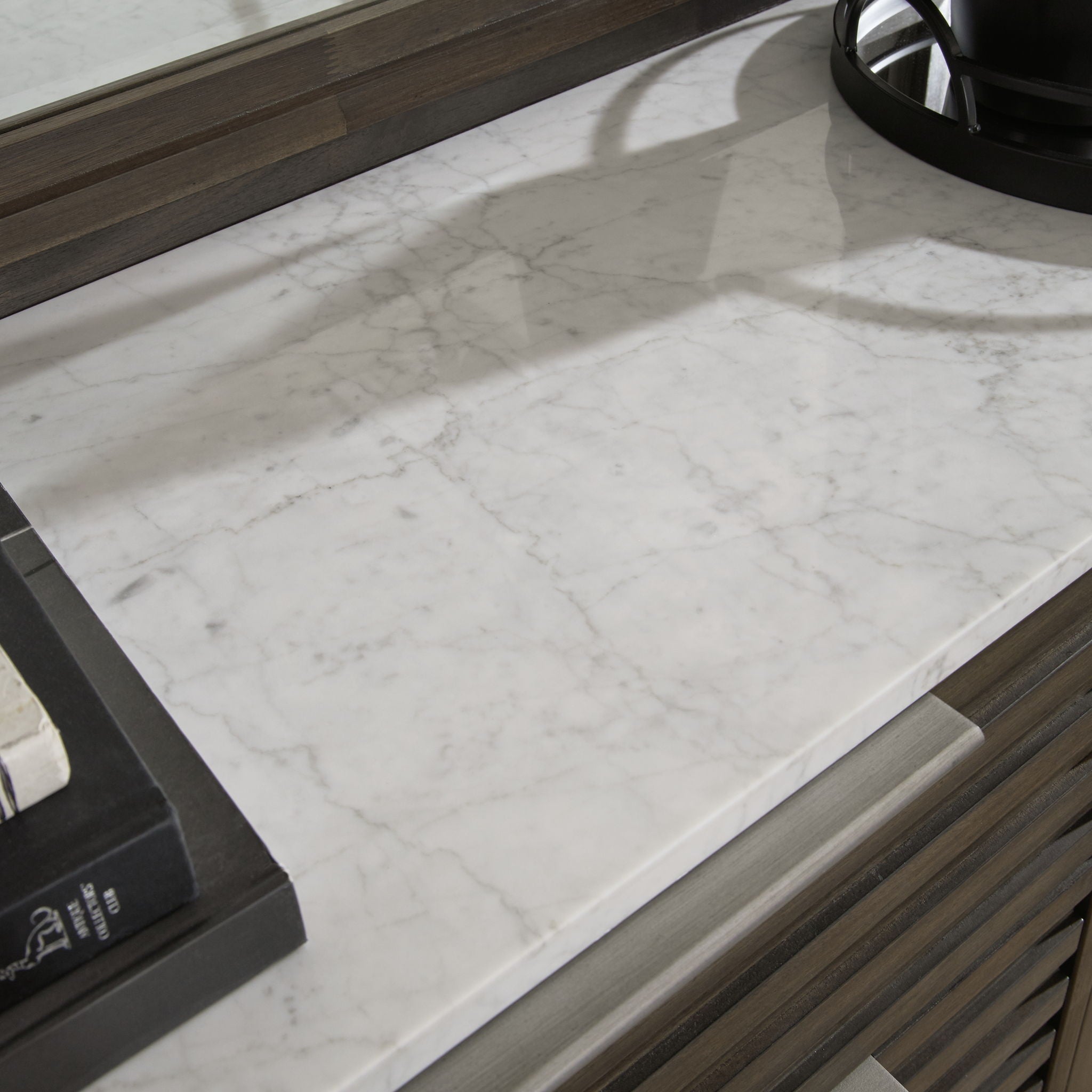 Dark brown dresser top with white marble surface and raised edge trim