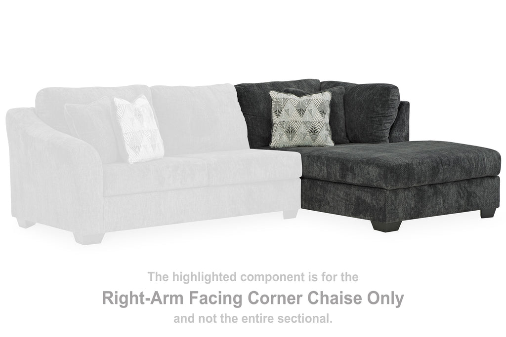 Dark gray right-arm facing corner chaise, with patterned throw pillow and tufted backrest.