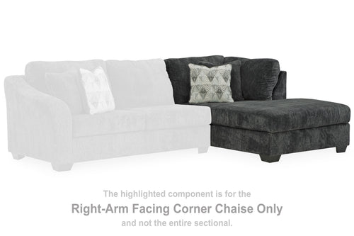 Dark gray right-arm facing corner chaise, with patterned throw pillow and tufted backrest.