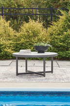 Gray round patio table with white marble-look top and slender cross legs