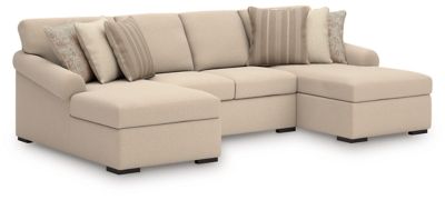 Light beige sectional sofa with corner chaise and stacked striped throw pillows