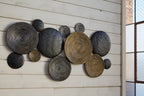 Assorted metallic circular wall decor discs in dark gray and bronze tones.