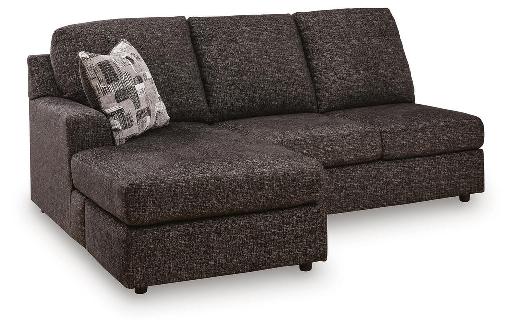 Dark gray sofa chaise with left arm, tufted cushions, and patterned throw pillow