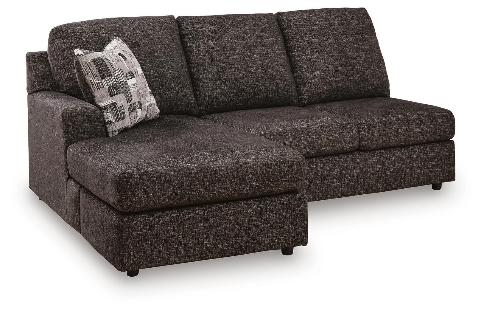 Dark gray sofa chaise with left arm, tufted cushions, and patterned throw pillow