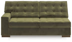 Olive tufted sofa with split back cushions, wide arms, and padded seat