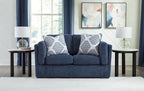 Blue loveseat sofa with two white-and-blue striped throw pillows