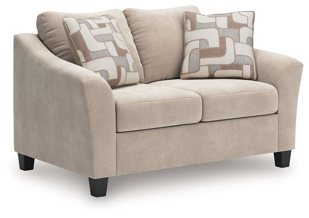 Taupe loveseat with two seat cushions and two patterned throw pillows