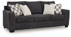 Dark gray upholstered sofa with patterned and solid white accent pillows