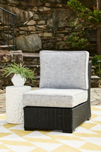 Light gray armless outdoor chair cushion on black woven wicker base