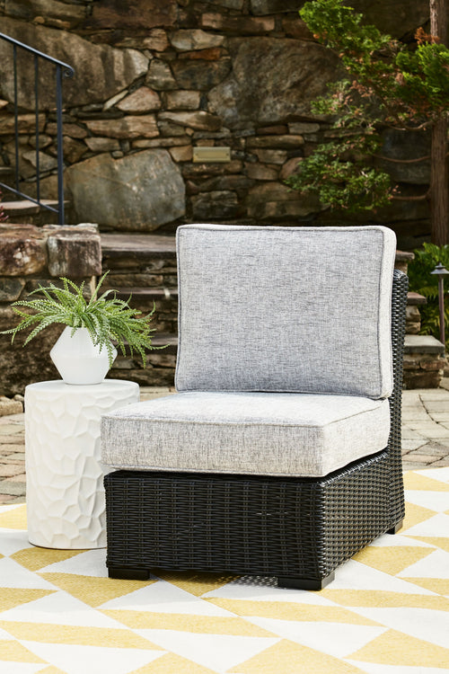 Light gray armless outdoor chair cushion on black woven wicker base