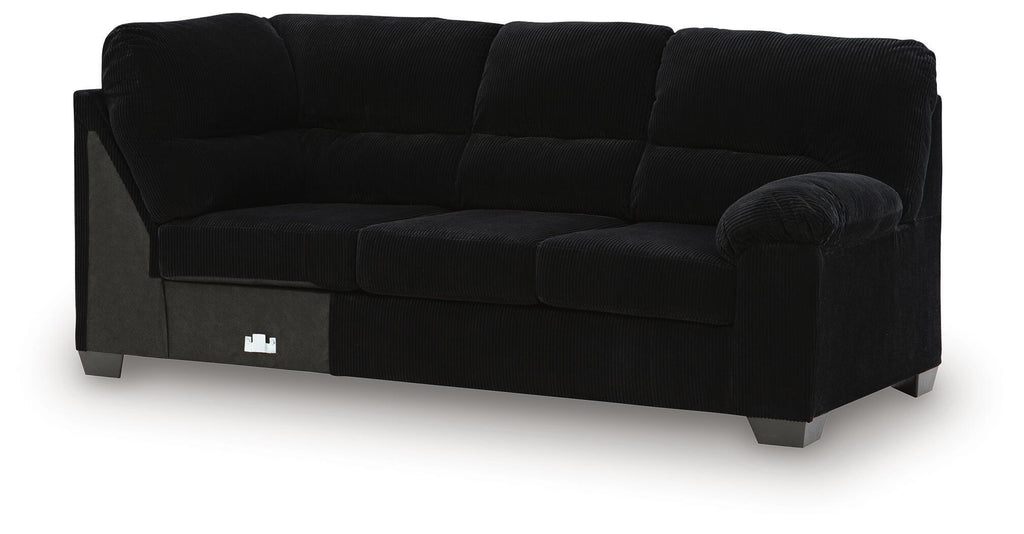 Dark fabric sofa with corner wedge, rounded arms, cushioned back and seat