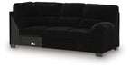 Dark fabric sofa with corner wedge, rounded arms, cushioned back and seat