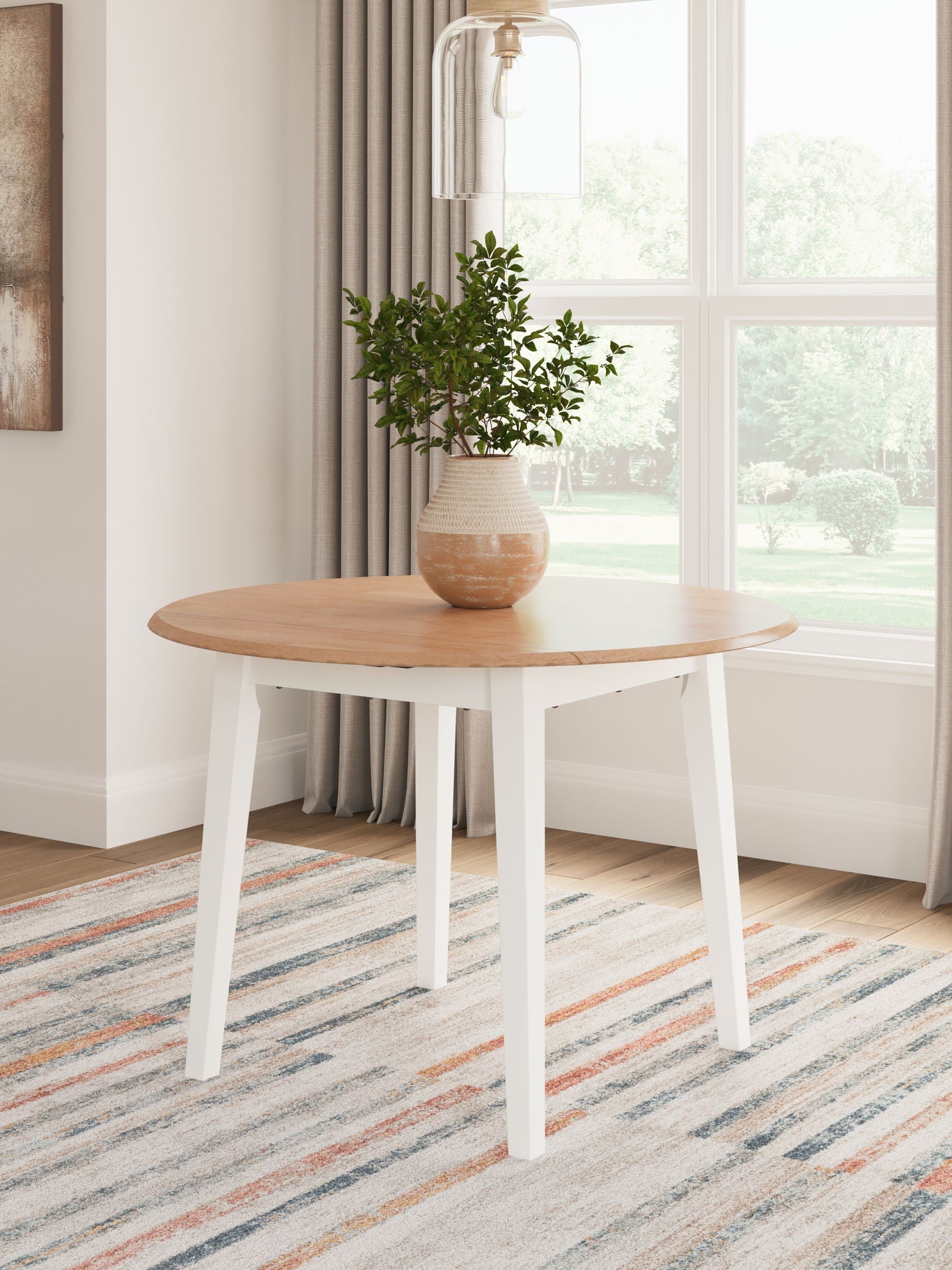 Round drop-leaf dining table with light wood oval top and white legs