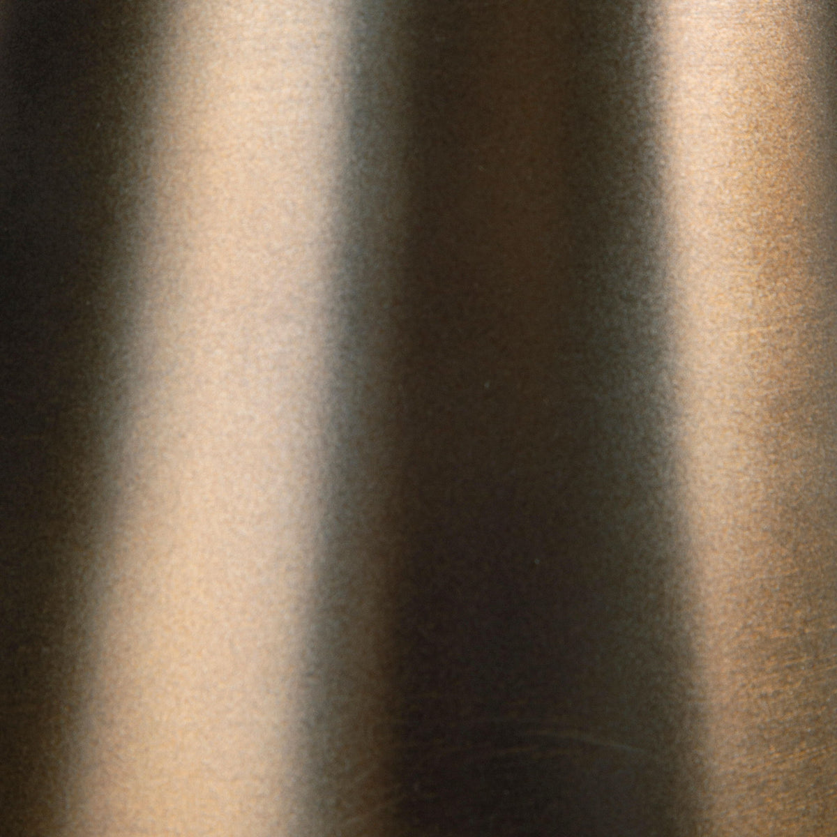 Bronze accent table pedestal finish texture close-up with smooth metal sheen