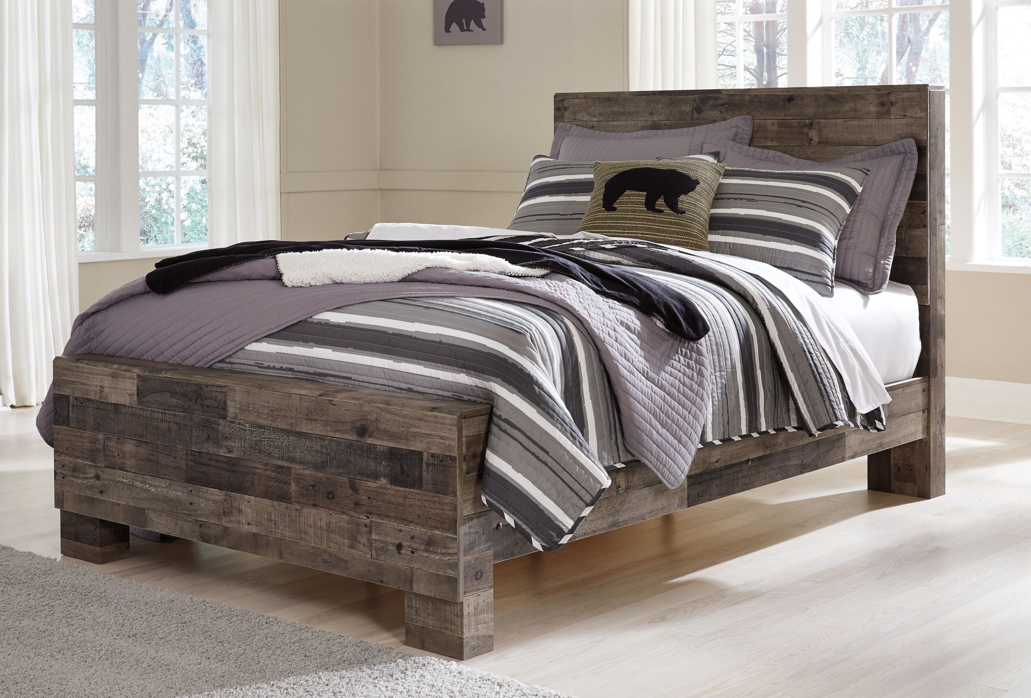 Rustic panel bed with dark wood frame and striped bedding with gray and black layers