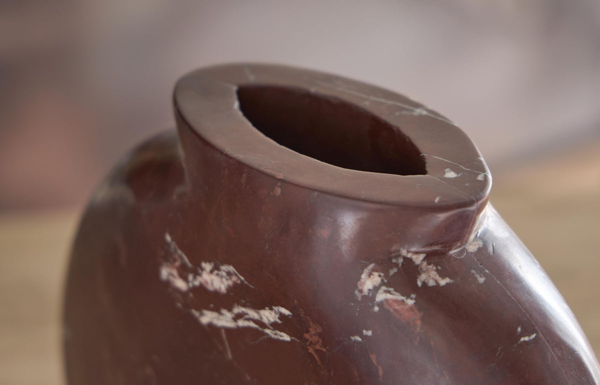 Close-up of dark red-brown ceramic vase rim with white distressed marks