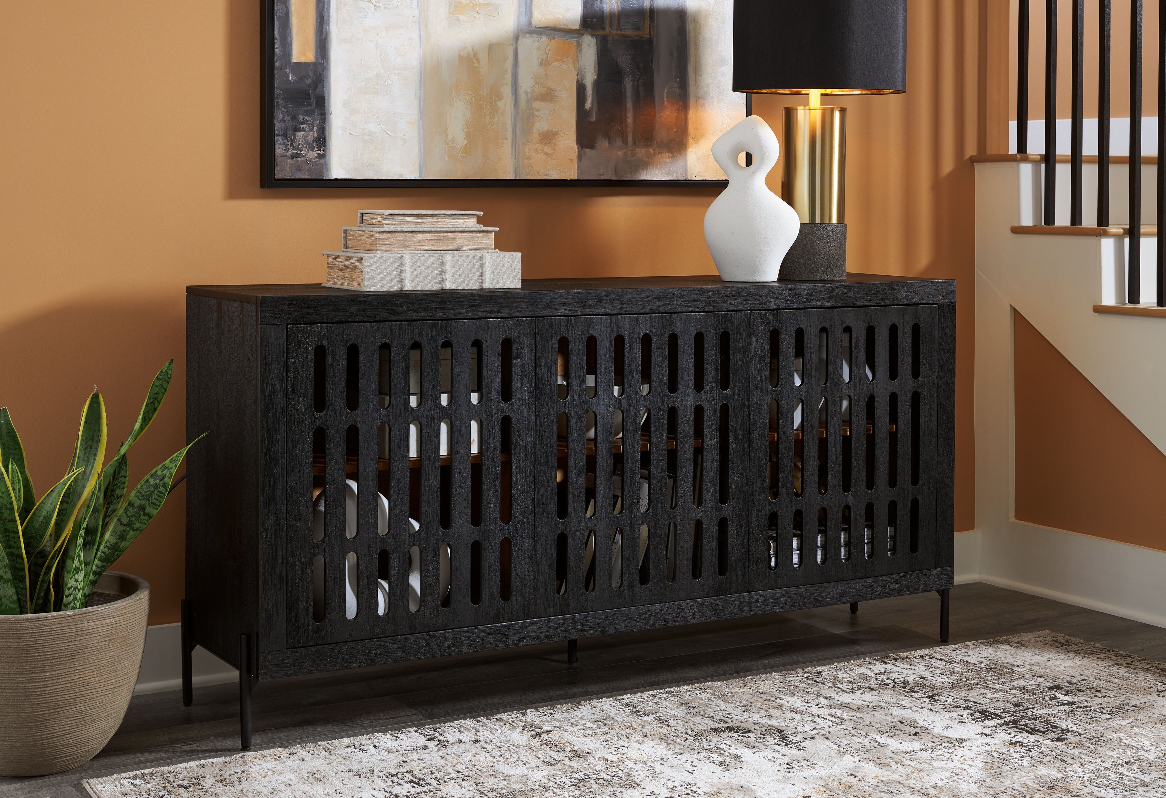 Black accent cabinet with vented slatted doors and four thin legs