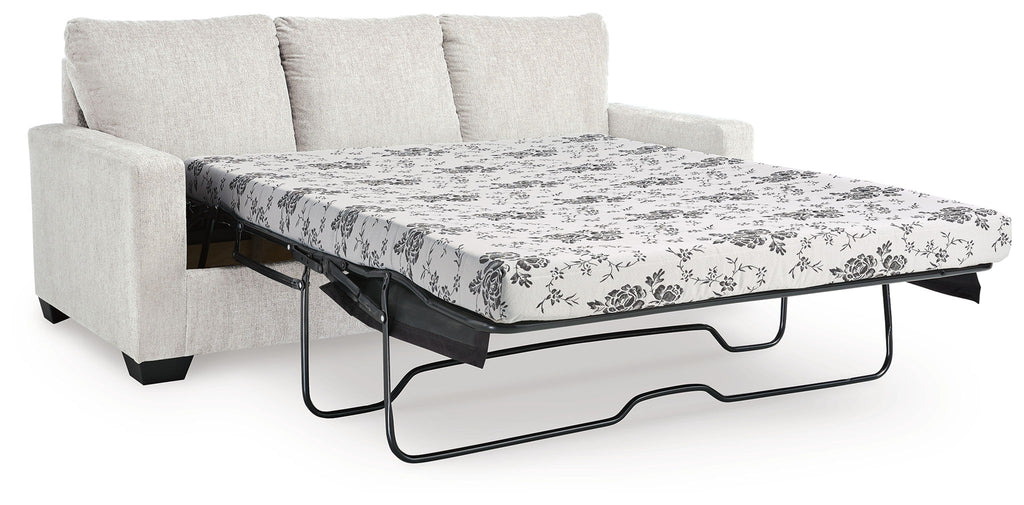 Beige sofa bed with pulled-out mattress and floral patterned cover