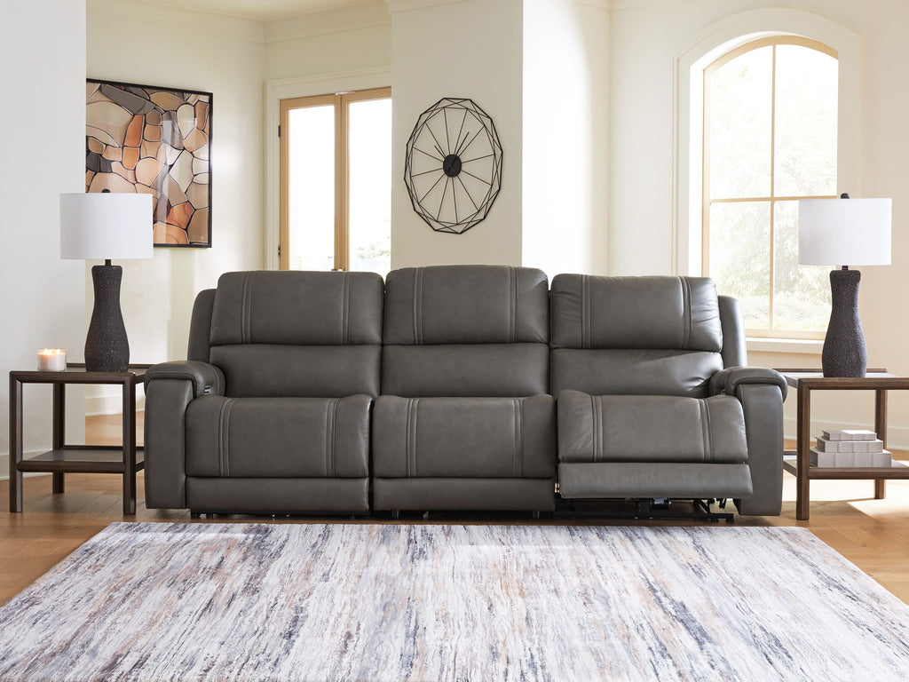 Dark gray power reclining loveseat with three cushions and padded arms, recline mechanism visible
