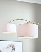 Gold arc floor lamp close-up with two white drum shades