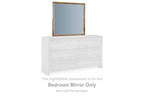Small brown framed bedroom mirror mounted on white dresser