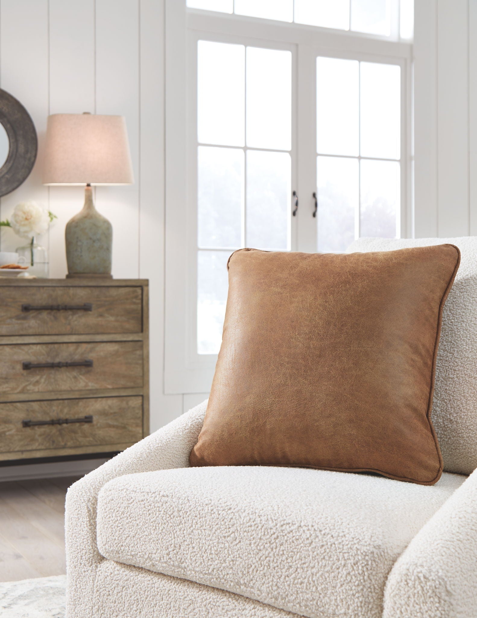 Cortnie light brown square pillow on cream upholstered sofa