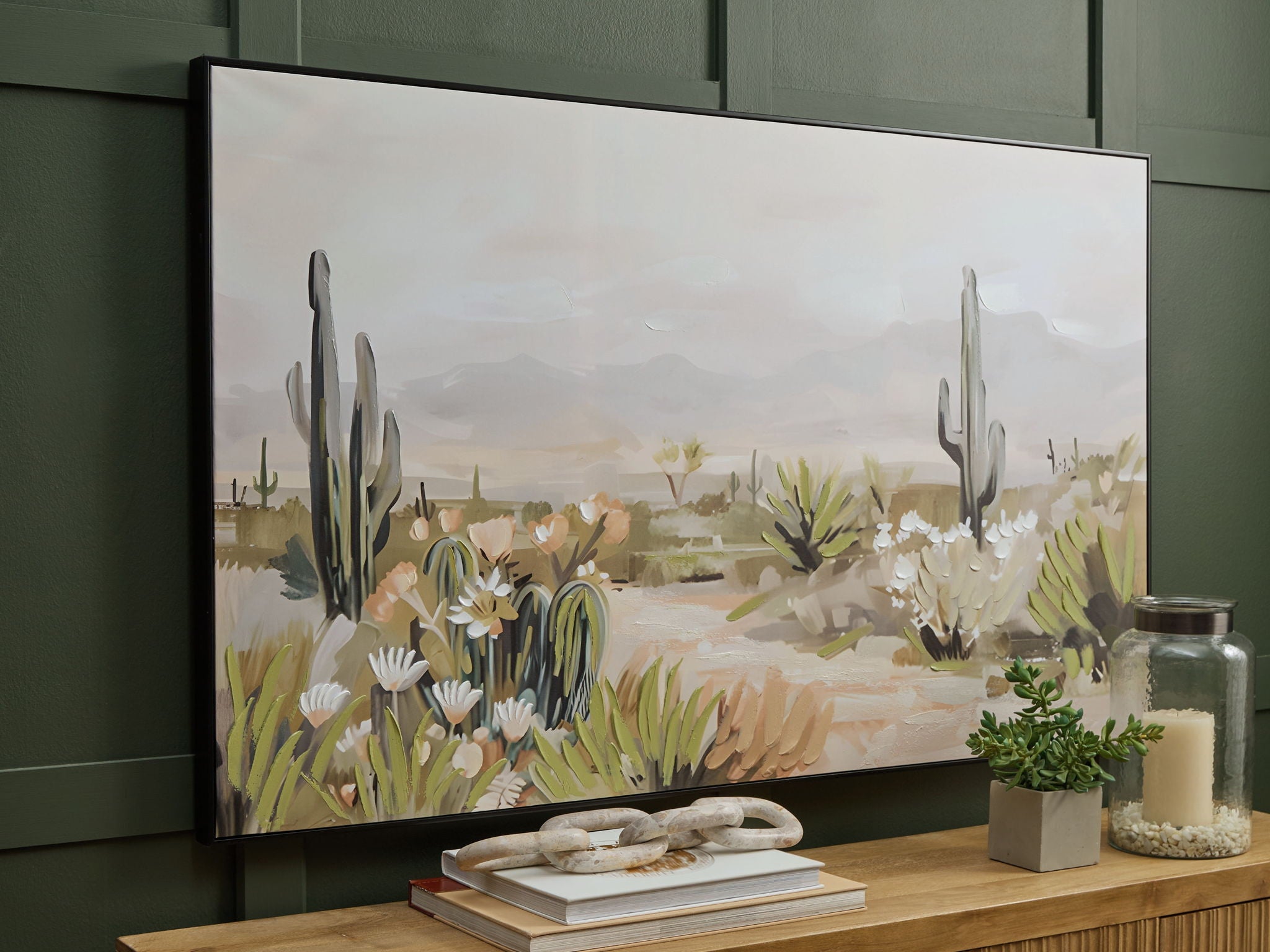 Framed wall art displayed on wall with desert cacti, white flowers, and desert path scene