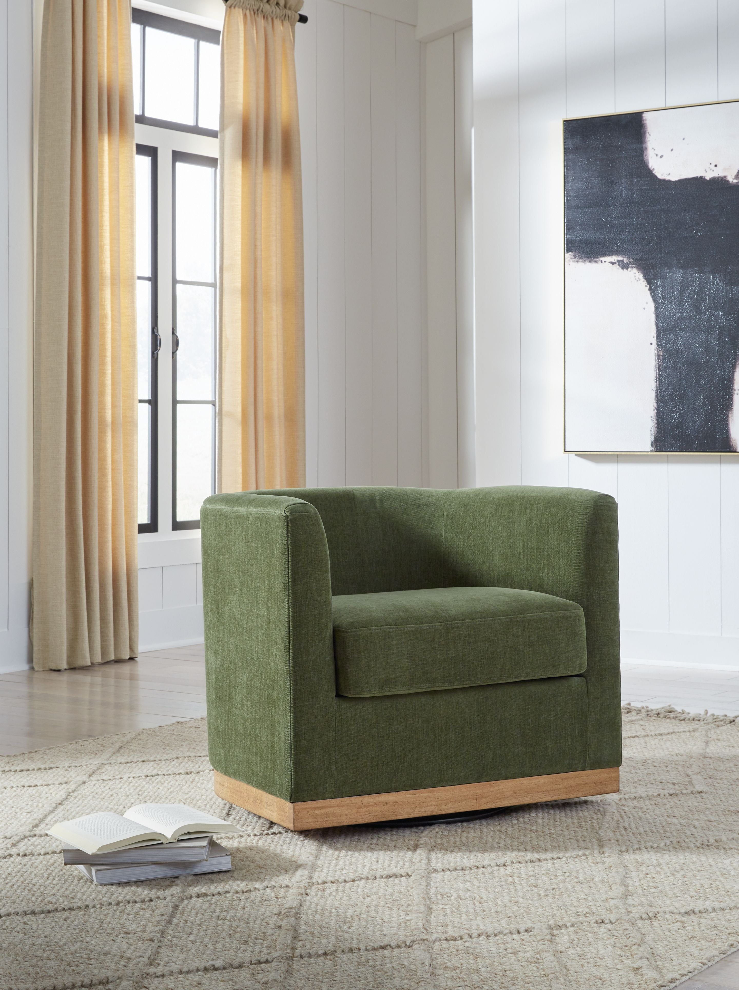 Forest green swivel accent chair in room, upholstered arms and seat with light wood base