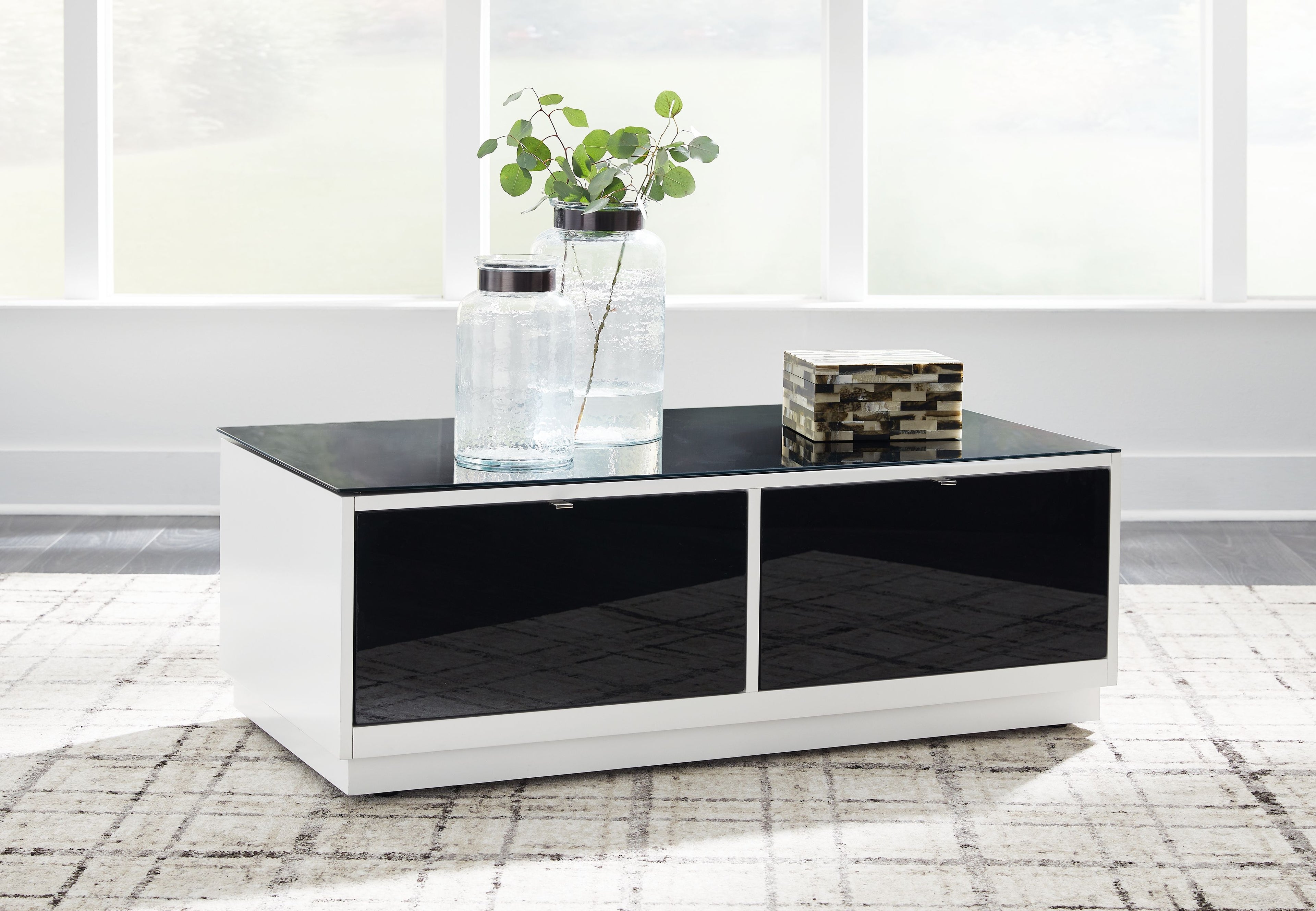 Rectangular cocktail table with white sides, two black drawers, and dark tabletop