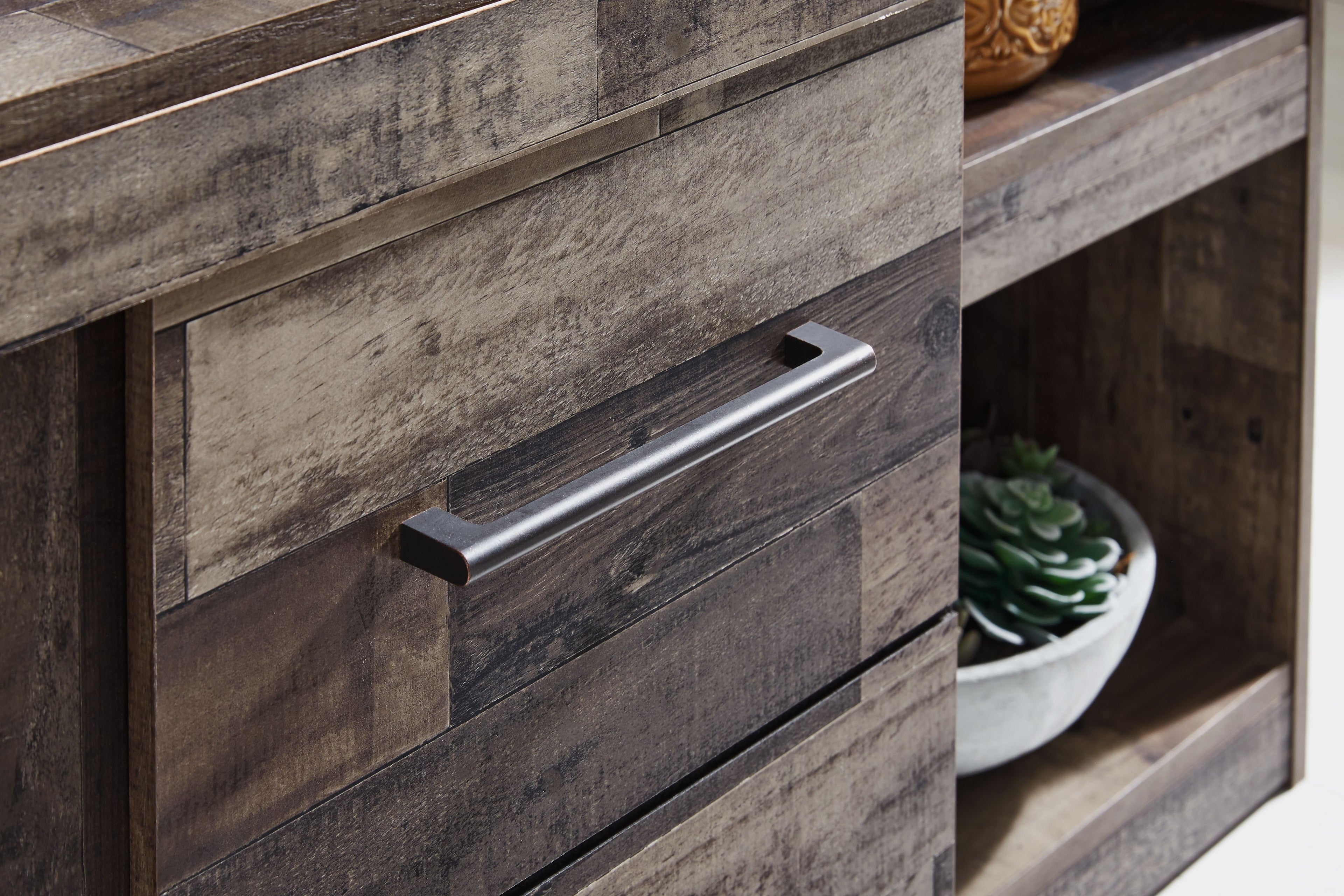 Entertainment center drawer with dark gray wood panel and brushed metal pull