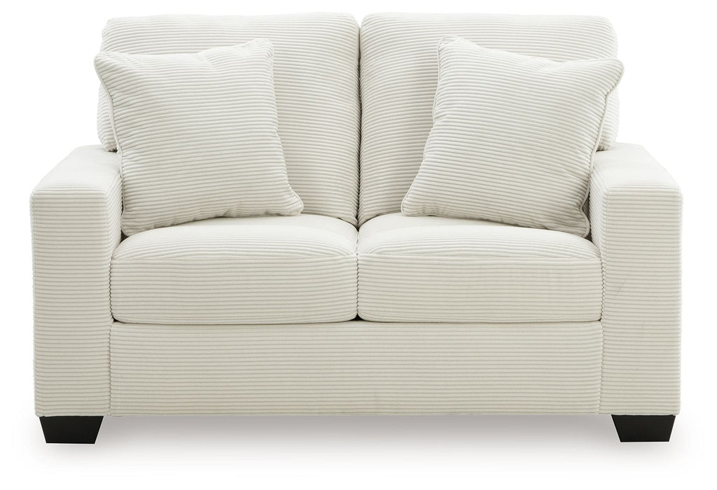Upholstered loveseat with two seat cushions and three tall striped back pillows, light upholstery