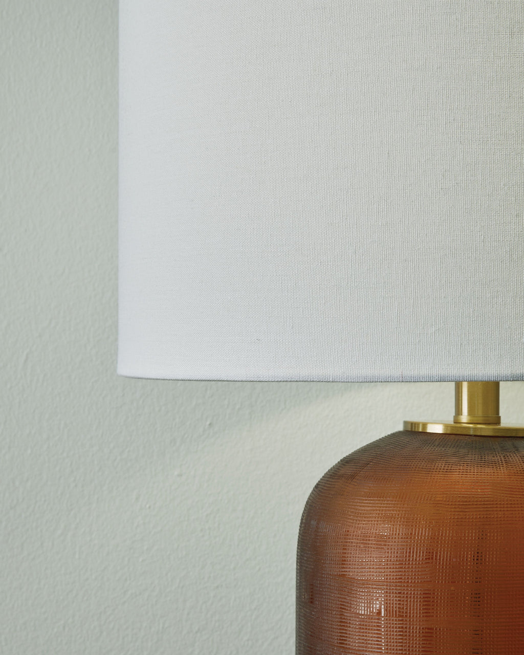 Amber glass lamp body with brass hardware and white drum shade