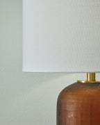 Amber glass lamp body with brass hardware and white drum shade