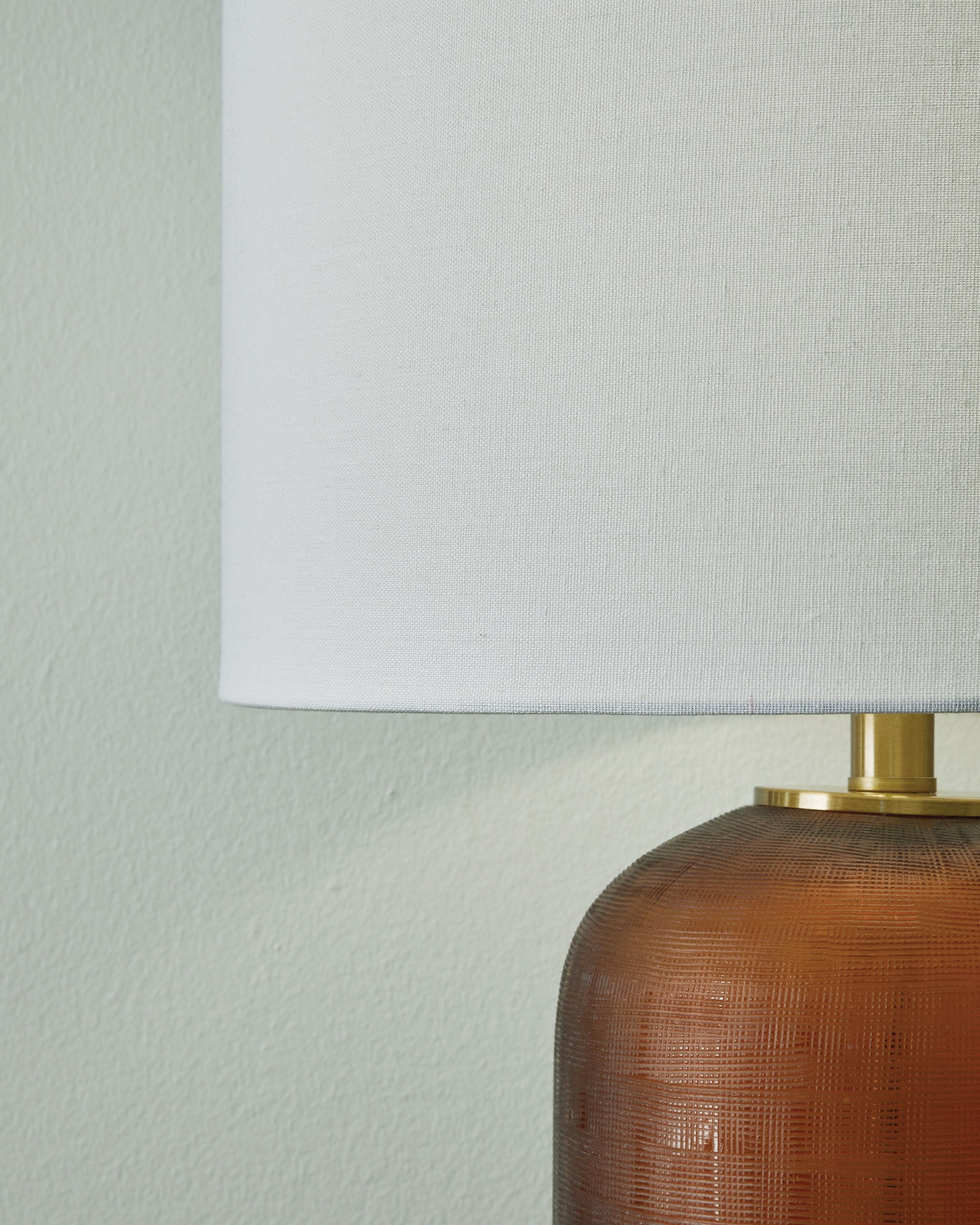 Amber glass lamp body with brass hardware and white drum shade