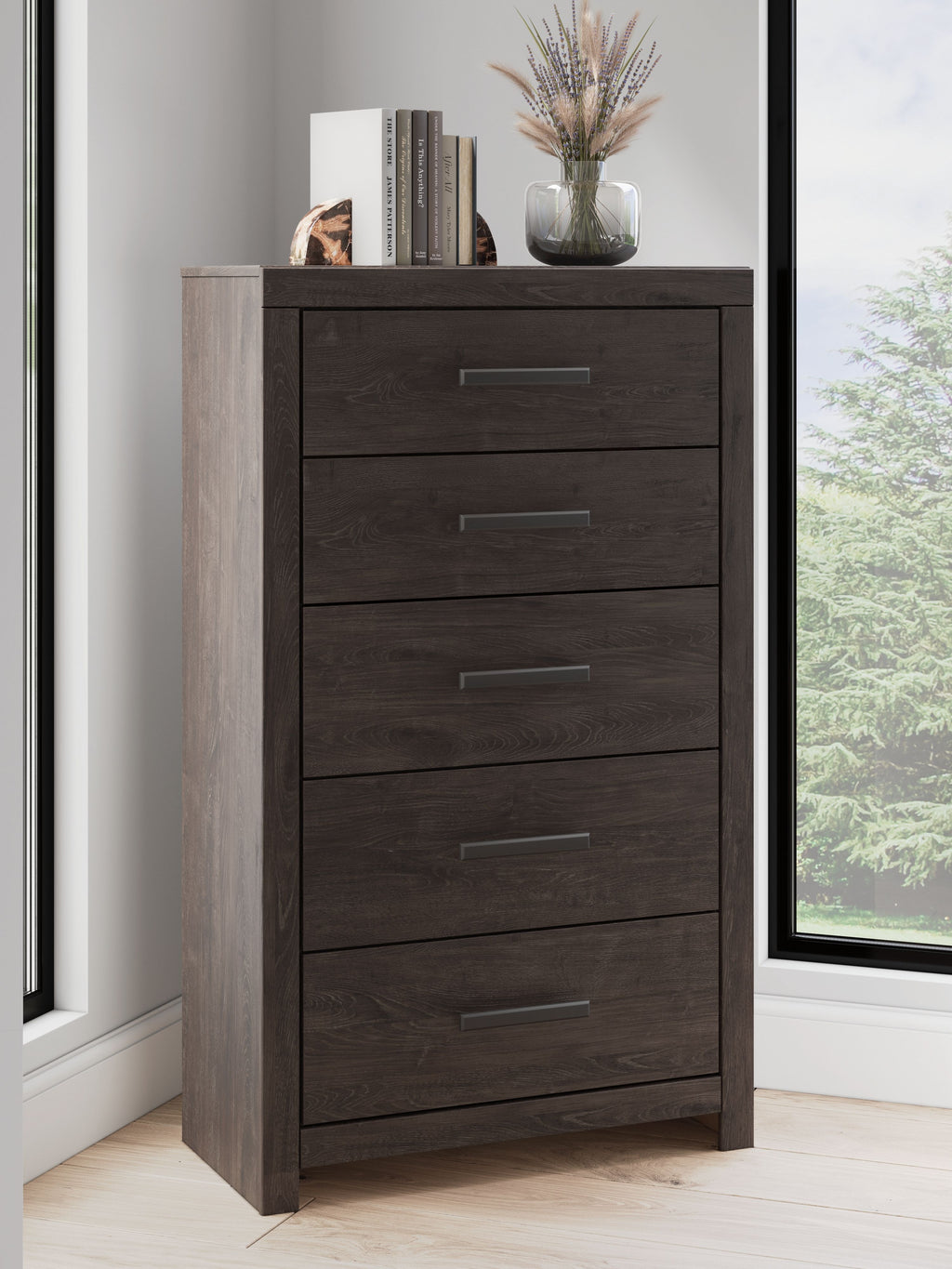 Charcoal five-drawer chest with metal bar handles; visible drawers and base.