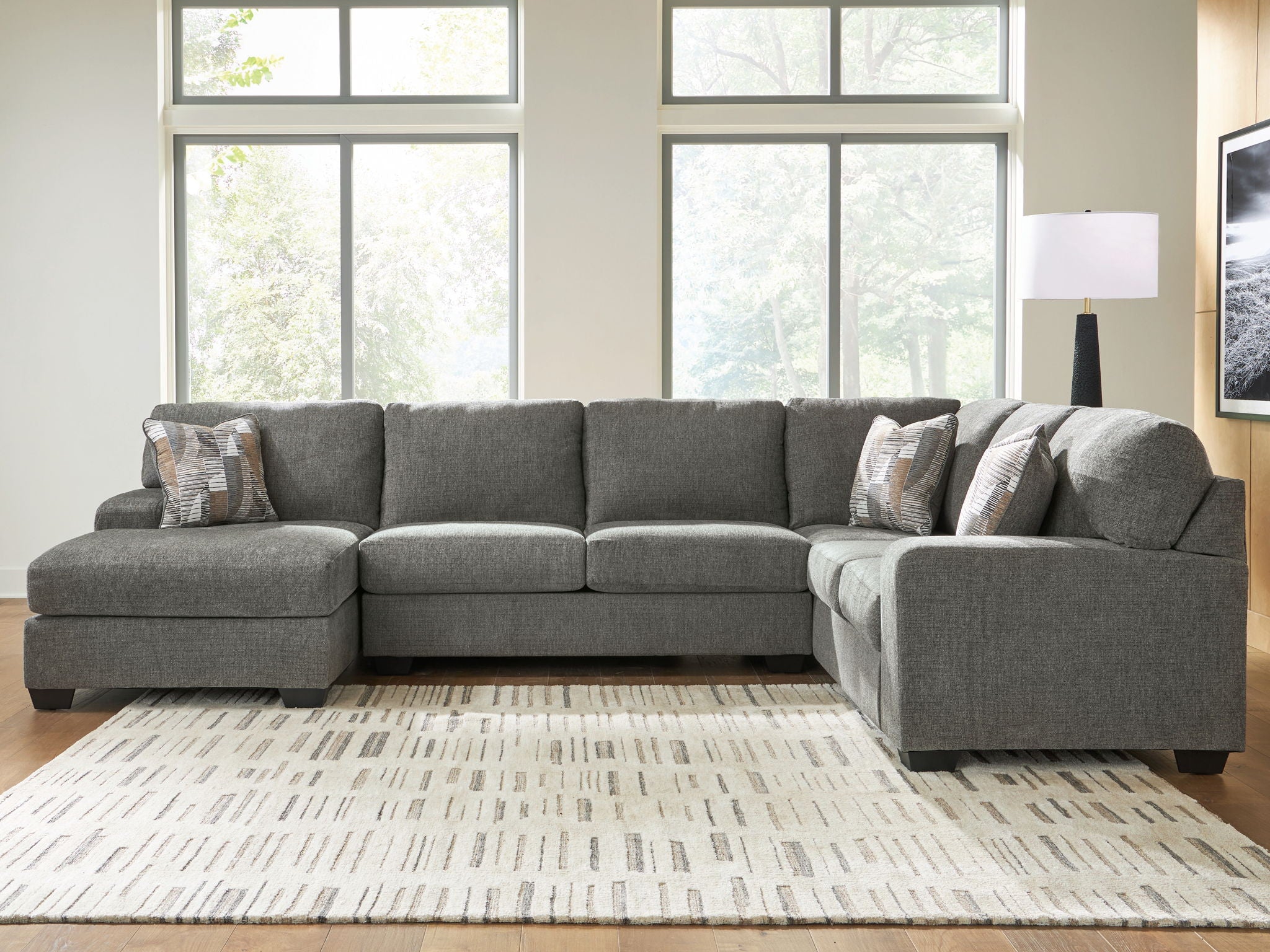 Gray sectional sofa with chaise, square arms, and multiple accent throw pillows