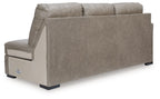Beige fabric sofa chaise with upright back panel and wide arm, black feet