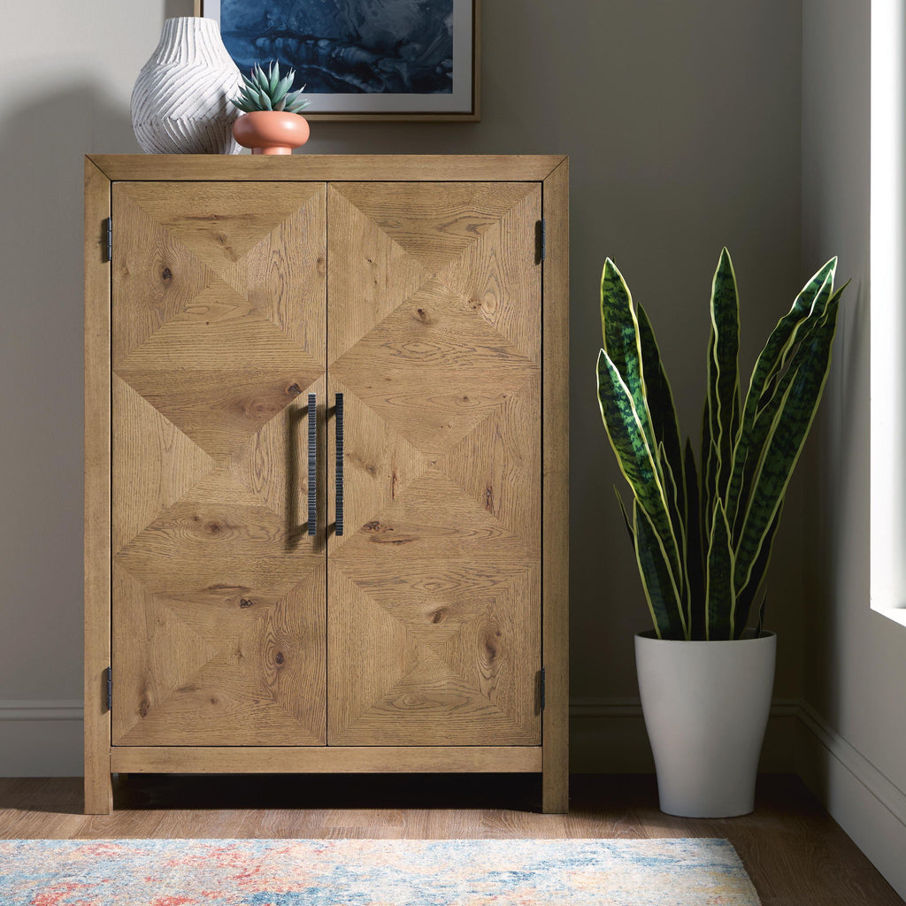 Light brown wooden bar cabinet with two paneled doors and vertical bar handles