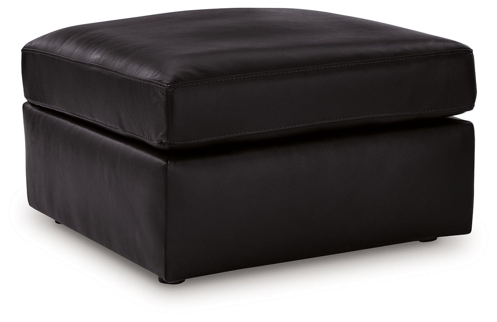 Black oversized accent ottoman with rounded edges and padded top