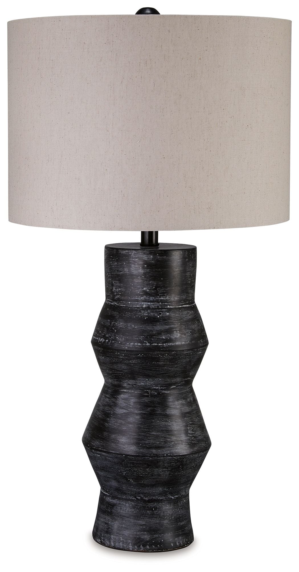 Distressed black table lamp with beige drum shade and ribbed pedestal base.
