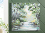 Framed landscape wall art with green foliage, gray waterfall, and light white sky