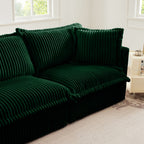 Green sectional sofa with tufted back cushions and ribbed slipcover