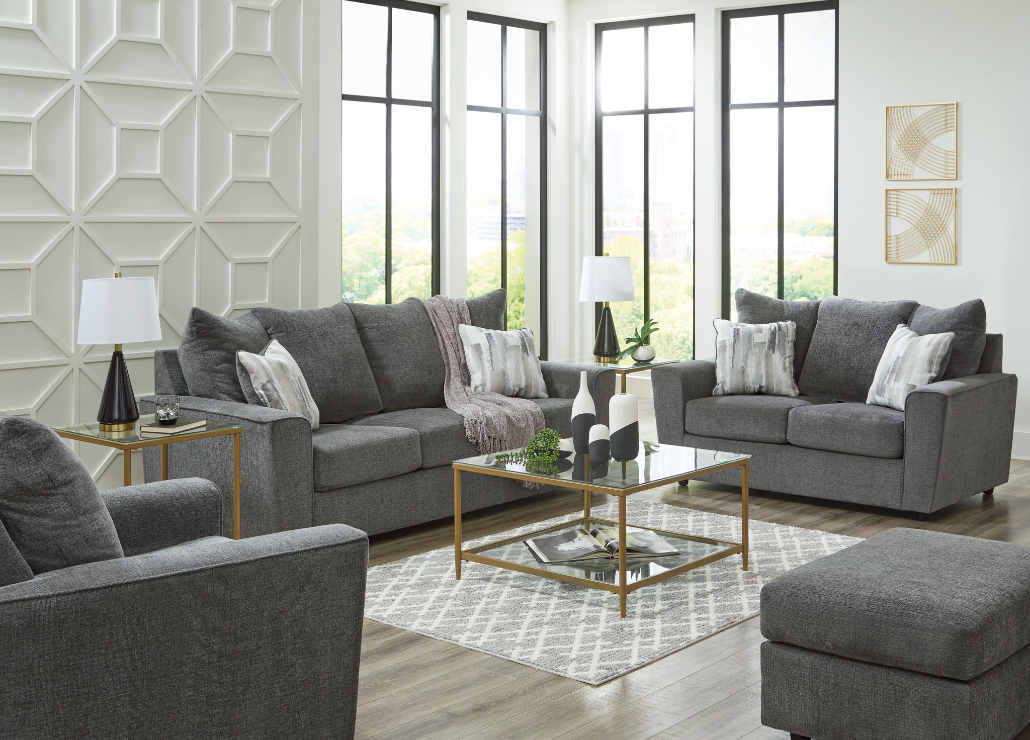 Dark gray fabric living room set with two loveseats and a matching ottoman.