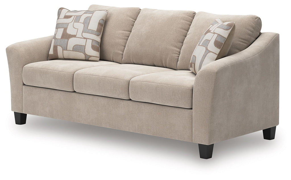 Taupe fabric sofa with rounded arms, three seat cushions, and patterned back pillows