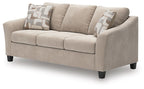 Taupe fabric sofa with rounded arms, three seat cushions, and patterned back pillows