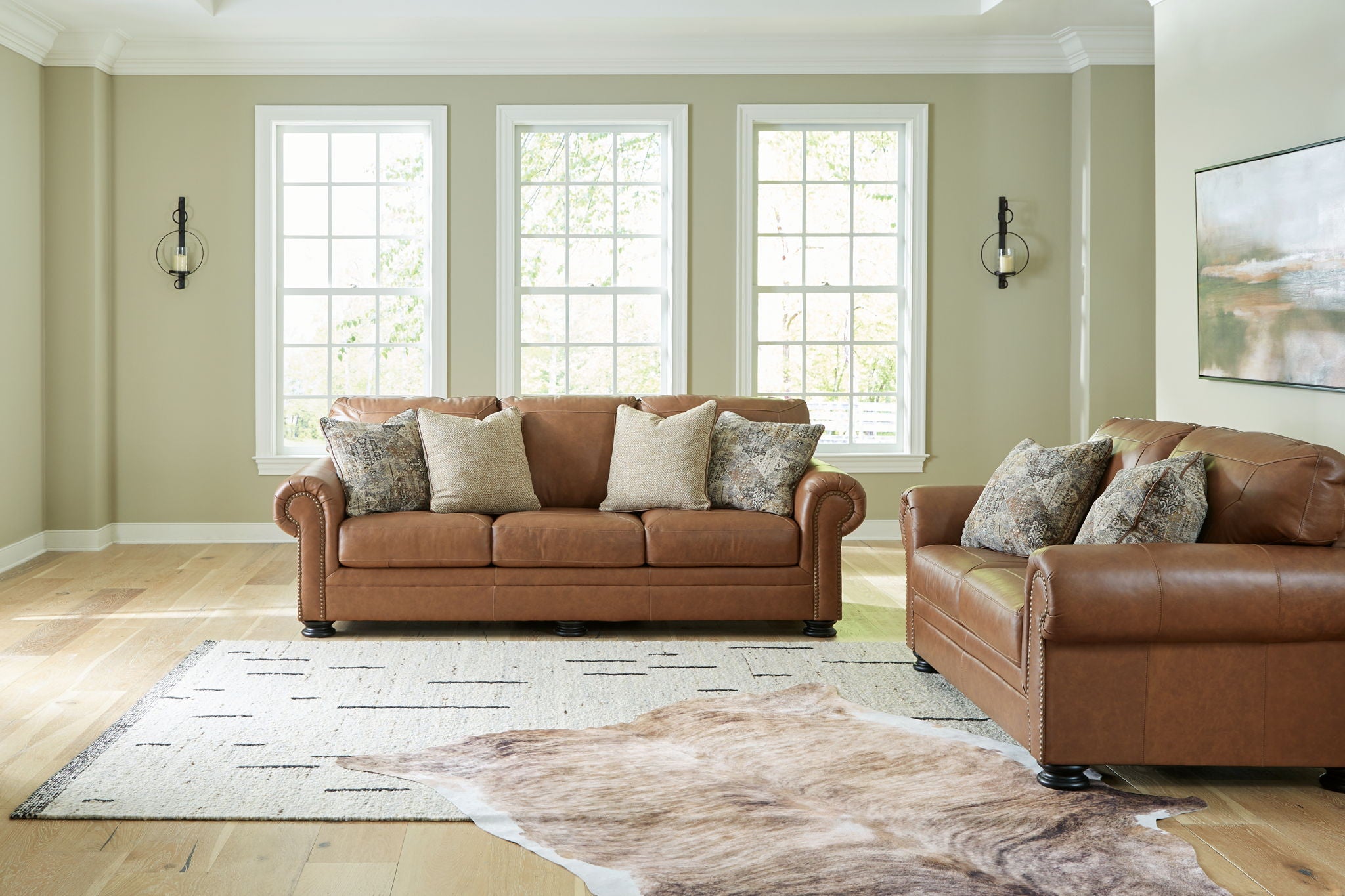 Brown fabric sofa and matching armchair with patterned throw pillows
